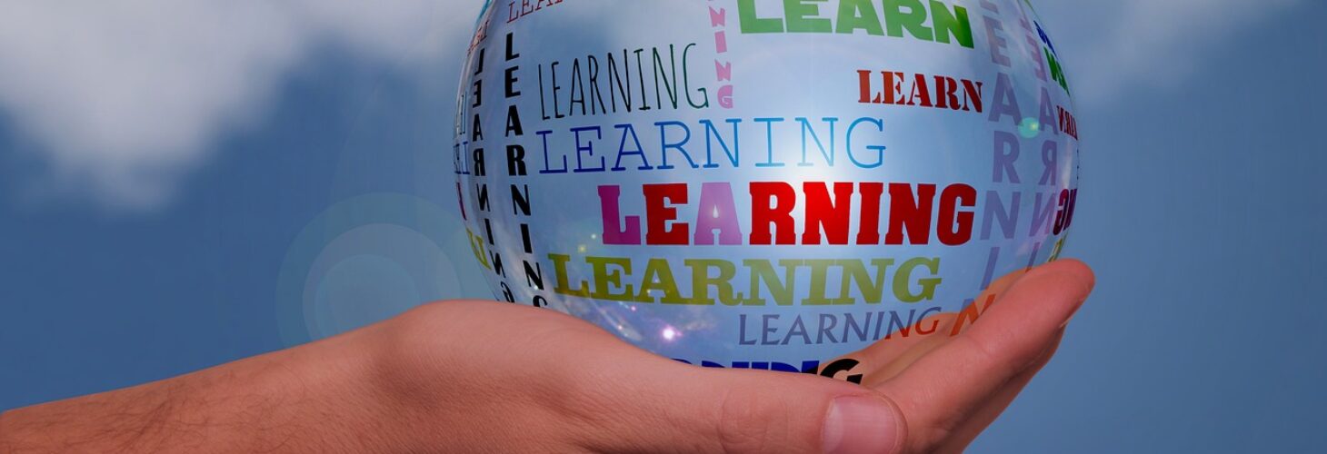 A hand holding a bubble with the word learning inside of it.