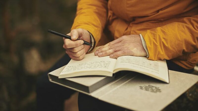 a man writing in a notebook