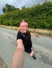 a person running whilst smiling for a selfie.